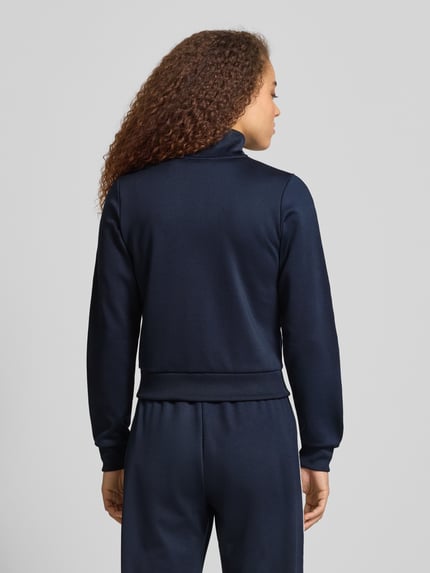 Frauenmodel trägt Regular Fit Trackjacke mit Logo-Stitching von Review in Dunkelblau mit Stehkragen und elastischen Abschlüssen, Ganzkörperansicht Rückansicht.