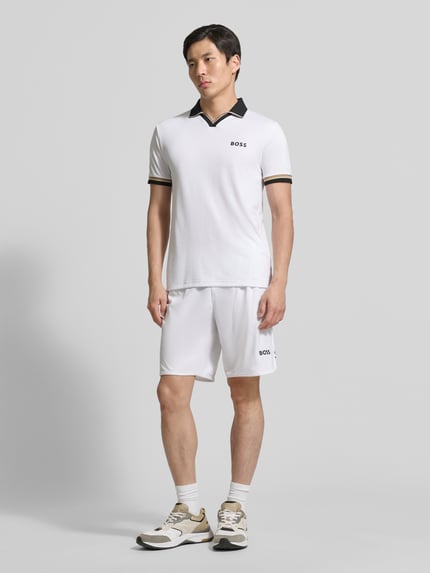 Männermodel trägt Relaxed Fit Sport-Shorts mit Logo-Print Modell 'SH_TOC SPIN 9 INCH' von BOSS Green, Optik: Unifarben, Kontraststreifen, Tunnelzug, elastischer Beinabschluss, seitliche Eingrifftaschen, Ganzkörperansicht von vorne.