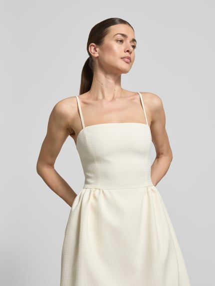 Frauenmodel trägt Tailliertes Cocktailkleid mit Viskose-Anteil Modell 'Kejani' von HUGO, cremefarben, strukturierter Jacquard, Nahaufnahme Oberkörper.