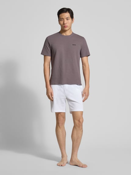 Männermodel trägt Regular Fit Pyjama-Oberteil aus Baumwoll-Mix Modell 'WAFFLE' von BOSS in Braun, unifarben, Kurzarm, Ganzkörperansicht von vorne.