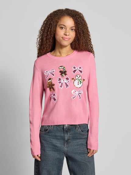 Frauenmodel trägt Rollkragenpullover mit weihnachtlichem Motiv-Print von ONLY, mehrfarbig, Strickoptik, Nahaufnahme Oberkörper.