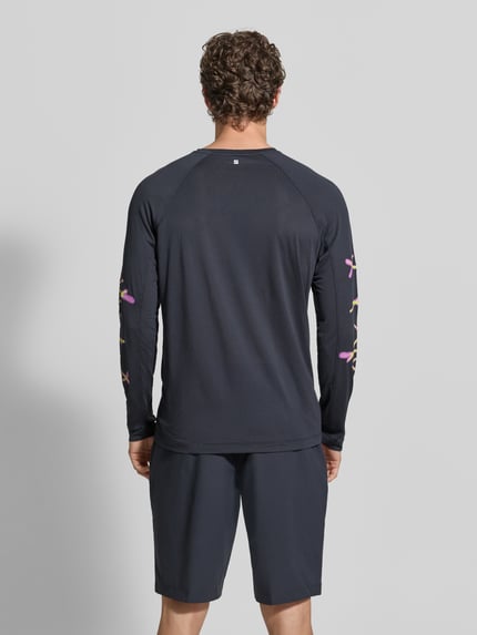 Męski model ma na sobie Funktionsshirt mit Logo Modell 'Kout' od Salomon, krój regular fit, longsleeve, kolor ciemny, widoczny nadruk logo, okrągły dekolt, długość tyłu w rozmiarze M 70 cm, widok całej sylwetki od tyłu.