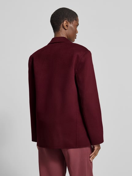 Frauenmodel trägt Regular Fit Kurzblazer mit Pattentaschen Modell 'QUINN' von Anine Bing, bordeauxrot, strukturierte Webware, Ganzkörperansicht Rückansicht.