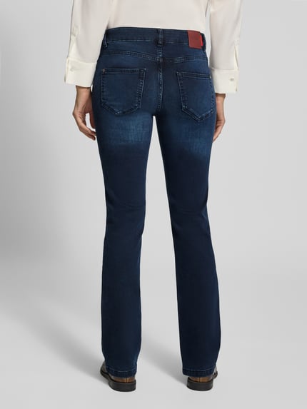 Frauenmodel trägt Flared Fit Jeans aus elastischem Baumwoll-Mix Modell 'Ashley' von MOS MOSH in Dunkelblau, 5-Pocket-Design, Ganzkörperansicht Rückansicht.