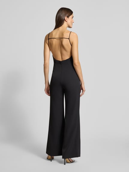 Frauenmodel trägt Jumpsuit mit Eingrifftaschen von Mango in Schwarz, lockerer Schnitt, Spaghettiträger, Rückenfrei, Ganzkörperansicht Rückansicht.