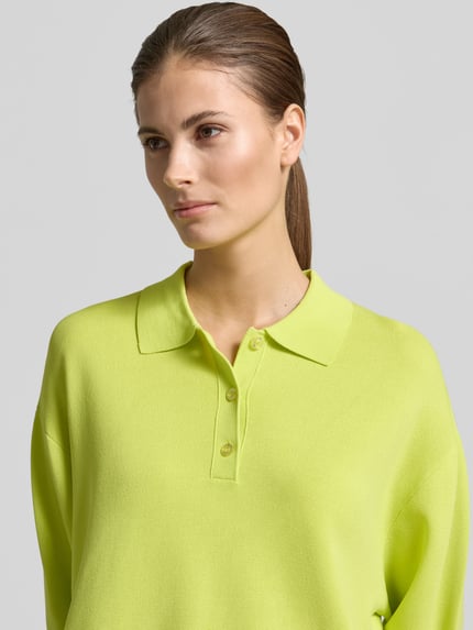 Modelka kobieca nosi Relaxed Fit Pullover in Strick-Optik od KARO KAUER EXKLUSIV w jasnożółtym kolorze, polo kołnierzyk, tekstura dzianinowa, detaliczne wykończenia rękawów, widok na górną część ciała z przodu.