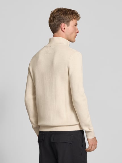 Männermodel trägt Slim Fit pullover aus puur katoen Model 'MILANO' van JACK & JONES premium in tricotlook, ruglengte maat M 73 cm, mouwlengte 68 cm, gebroken wit, zwarte broek, geheellichaams vanaf achteren.