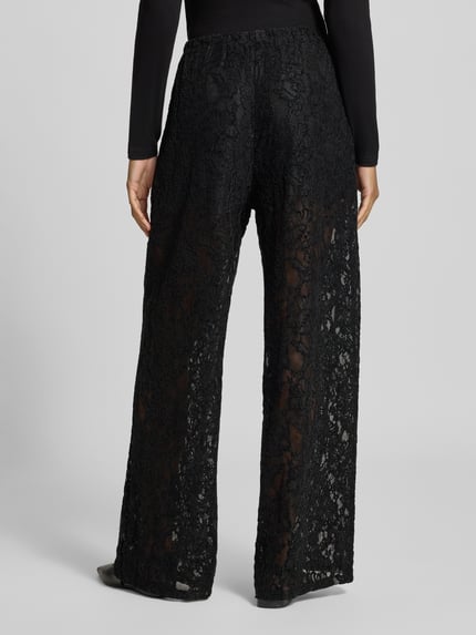 Frauenmodel trägt Wide Leg Hose aus Spitze Modell 'COCO' von Topshop, schwarz, transparenter Material-Mix, Rückansicht, Bundweite 70 cm, Innenbeinlänge 80 cm.