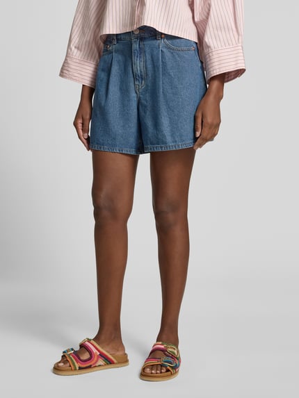 Frauenmodel trägt Jeansshorts mit Eingrifftaschen Modell 'GEMMA' von YAS aus Reine Baumwolle im Regular-Fit, mittleres Blau, Bundweite bei Größe 36: 37 cm, Innenbeinlänge bei Größe 36: 41 cm, Ganzkörperansicht von vorne.