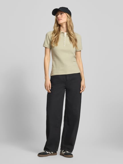 Frauenmodel trägt Slim Fit Poloshirt mit Label-Stitching von Gant aus Baumwoll-Elasthan-Mix, Knopfleiste, Rückenlänge 59 cm, Ganzkörperansicht von vorne.