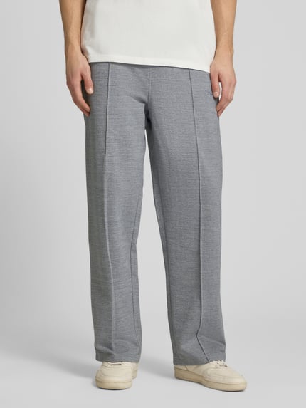 Männermodel trägt Track Pants mit Logo-Stitching Modell 'Skagen' von Pegador, Grau, Reine Baumwolle, Loose-Fit, Ganzkörperansicht von vorne.