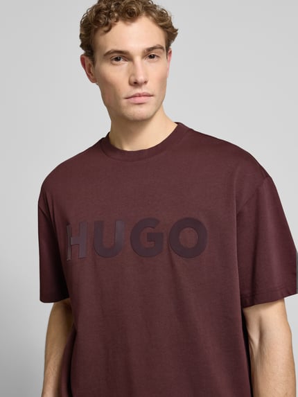 Mężczyzna nosi Oversized T-Shirt aus reiner Baumwolle Modell 'DINKEE' von HUGO, jednolity kolor, label print, dekolt okrągły, krótki rękaw, czysta bawełna, zbliżenie górnej części ciała
