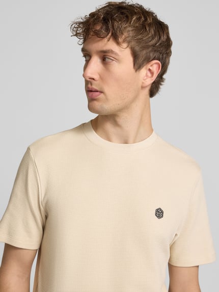 Männermodel trägt T-shirt met labeldetail model 'FILLIP' van Blend, puur katoen, recht model, ronde hals, ruglengte bij maat M 69 cm, Nahaufnahme Oberkörper.