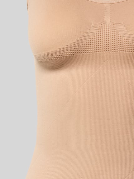 Vrouwenmodel draagt figurformend tanktop met brede bandjes van MAGIC Bodyfashion, beige, gladde stof, shapewear, detailopname bovenlichaam.