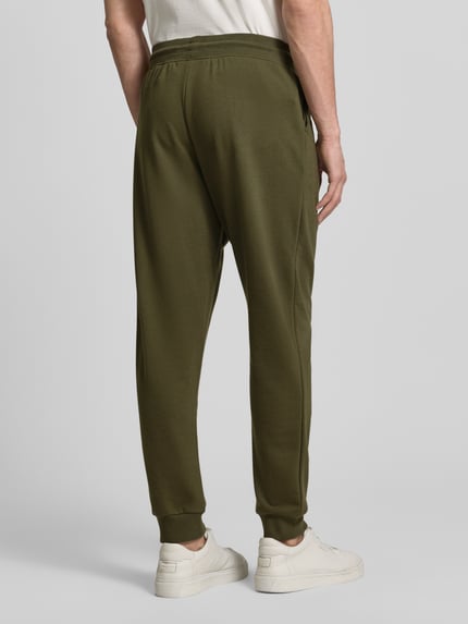 Męski model nosi Comfort Fit Sweatpants aus Baumwoll-Mix von Tommy Hilfiger, kolor jednolity, dzianina, widok całej sylwetki z tyłu.