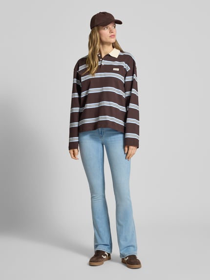 Frauenmodel trägt Flared Fit Jeans im 5-Pocket-Design von Review aus elastischem Baumwoll-Mix, helle Waschung, Ganzkörperansicht von vorne.