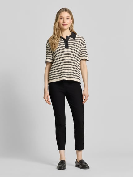 Frauenmodel trägt Slim Fit Stoffhose in verkürzter Passform von Christian Berg Woman in Schwarz, Baumwoll-Mix, Ganzkörperansicht von vorne, Bundweite bei Größe 36: 39 cm, Innenbeinlänge bei Größe 36: 66 cm, Knopf- und Reißverschluss.