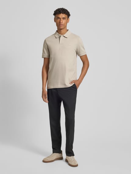 Männermodel trägt Slim Fit Poloshirt aus Baumwoll-Mix von BOSS Orange, Optik: Unifarben, Label-Patch, Piqué, Ganzkörperansicht von vorne.