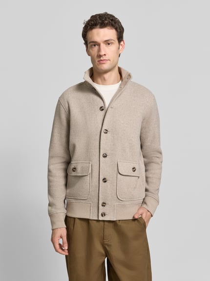 Männermodel trägt Strickjacke aus Wolle mit Stehkragen von RAGMAN in Beige mit Struktur, Knopfleiste, Pattentaschen, Ganzkörperansicht von vorne