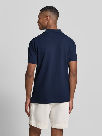 Męski model nosi Slim Fit Poloshirt aus Baumwoll-Mix von Polo Ralph Lauren, efekt: jednolity kolor, krój slim fit, detal z logo, kołnierzyk polo, zapięcie: krótka listwa guzikowa, rękaw: krótki rękaw, zakończenie: prążkowane, wykończenie: z rozcięciami po bokach, asymetryczny, wykończenie materiału: pika, materiał: mieszanka bawełny, zdjęcie całej sylwetki z tyłu