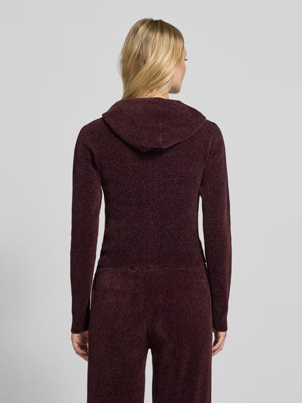 Frauenmodel trägt Sweatjacke mit Kapuze Modell 'MAYA KNIT HOODIE' von Juicy Couture, unifarben, Strickoptik, Rückenansicht