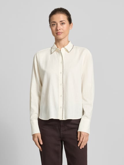 Kobiece modelka ma na sobie Leinenbluse mit Ziernaht und Kentkragen od Christian Berg Woman Selection, jasny beż, prosty krój, mieszanka lnu i wiskozy, guziki, z dekoracyjnym przeszyciem przy kołnierzyku, długość tyłu 62 cm, długość rękawa 60 cm, widok całej sylwetki z przodu.