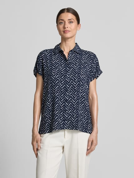 Kobiece modelka nosi Relaxed Fit Bluse aus Viskose im Allover-Look von Christian Berg Woman, ciemnoniebieski i biały wzór, krój relaxed fit, czysta wiskoza, kołnierzyk koszulowy, długość tyłu w rozmiarze 36: 63 cm, widok całej sylwetki z przodu.