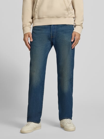 Männermodel trägt blaue Straight Fit Jeans aus reiner Baumwolle Modell '501®' von Levi's®, dezente Waschung, Herrenmode, Ganzkörperansicht von vorne.