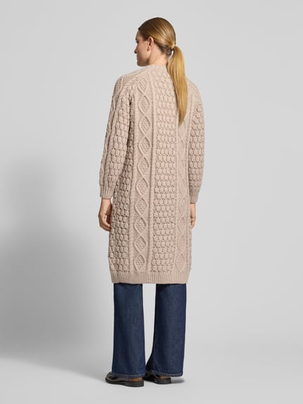 Frauenmodel trägt Longcardigan mit Zopfmuster von Apricot in Beige, offene Front, gerippte Abschlüsse, strukturierte Stricktextur, Ganzkörperansicht Rückansicht.