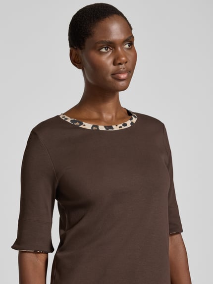 Frauenmodel trägt T-Shirt mit kontrastierendem Ausschnitt von MARC CAIN in Uni-Optik, Rundhals, Jersey, Nahaufnahme Oberkörper.