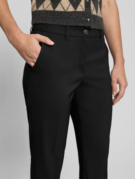 Vrouwenmodel draagt stoffen broek met persplooien van Betty Barclay, materiaalmix met stretch, steekzakken, strookzakken, nauwsluitend model, haak-, knoop- en ritssluiting, bandwijdte maat S 40 cm, binnenbeenlengte maat S 76 cm, detailopname heup.