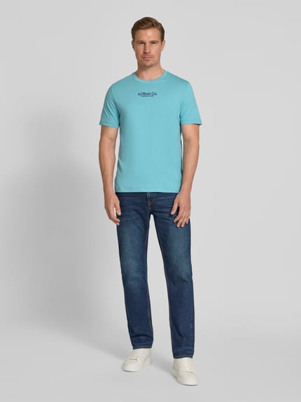 Männermodel trägt Regular Fit T-Shirt aus reiner Baumwolle von s.Oliver RED LABEL, Optik: Unifarben, Label-Schriftzug, Ganzkörperansicht von vorne.