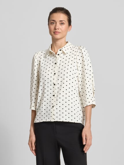 Frauenmodel trägt Regular Fit Bluse mit 3/4-Arm Modell 'Bono' von LOLLYS LAUNDRY, Allover-Look, creme mit schwarzen Punkten, Ganzkörperansicht von vorne.