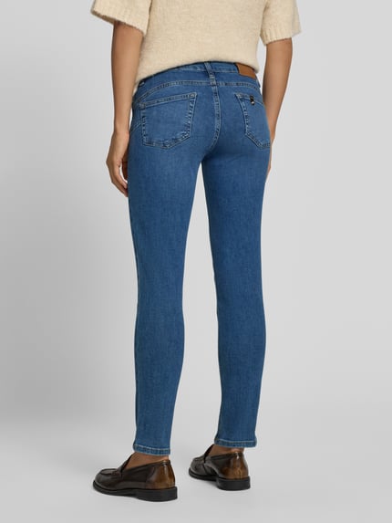 Frauenmodel trägt Skinny Fit Jeans aus elastischem Baumwoll-Mix Modell 'MONROE' von Liu Jo White in Blau, Ganzkörperansicht Rückansicht. 5-Pocket-Design, Gürtelschlaufen, Knopf- und Reißverschluss, Damen Jeans, Bundweite 36 cm, Innenbeinlänge 68 cm.