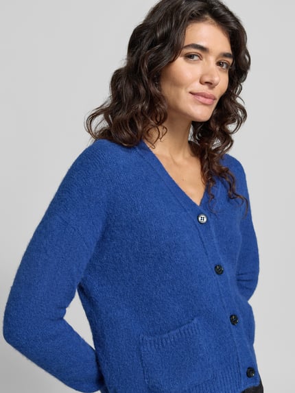 Frauenmodel trägt Cardigan aus Alpaka mit aufgesetzten Taschen von MAX MARA WEEKEND in Blau, Strukturstrick, Knöpfe, Nahaufnahme Oberkörper.