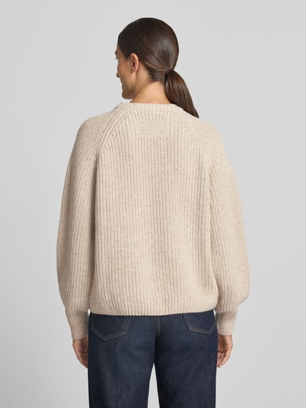 Modelka nosi sweter Loose Fit Pullover aus Woll-Mix model 'RIB KNIT' od armedangels, beżowy, gruba dzianina, widok całej sylwetki z tyłu, sweter damski.