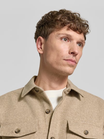 Männermodel trägt Regular Fit Hemdjacke mit Brusttaschen von LERROS in Beige, glatte Textur, Nahaufnahme Oberkörper, Damen Hemdjacke, Umlegekragen, durchgehende Knopfleiste.