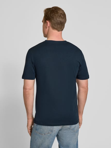 Männermodel trägt Regular Fit T-Shirt aus reiner Baumwolle van s.Oliver RED LABEL, effen donkerblauw, jersey, met ronde hals en korte mouwen, ganzkörperansicht rückansicht.