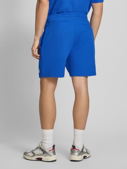Męski model nosi Regular Fit Sweatshorts aus Baumwoll-Mix Modell 'NUWAFFLO' von HUGO, efekt: jednolity kolor, krój regular fit, naszywka z logo, tunel, ściągacz, wpuszczane kieszenie, kieszeń z tyłu, mieszanka bawełny, Ganzkörperansicht Rückansicht.