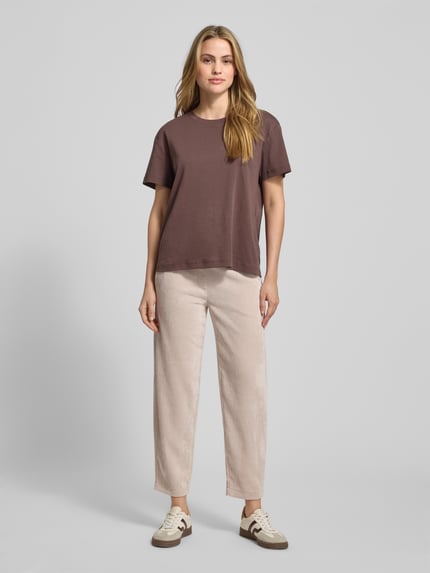Modelka kobieca nosi beżowe, sztruksowe spodnie z elastycznym pasem Cordhose mit elastischem Bund Modell 'EDEN' od Cambio, pełny widok z przodu, materiał z domieszką stretchu, skrócony fason.