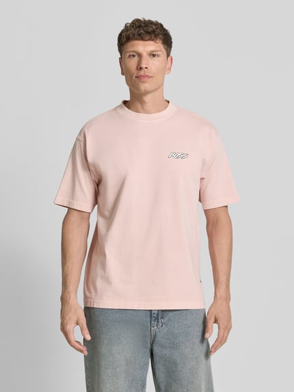 Männermodel trägt Regular Fit T-Shirt aus reiner Baumwolle Modell 'SURFWASH' von BOSS Orange, unifarben, Label Print, Rundhals, kurzarm, Jersey, Ganzkörperansicht von vorne.