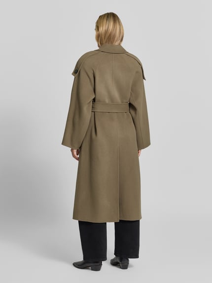 Frauenmodel trägt unifarbenen Longline-Mantel mit Bindegürtel Modell 'AQUALUNG' von IRO, strukturierte Webware, Oversized, Ganzkörperansicht Rückansicht.