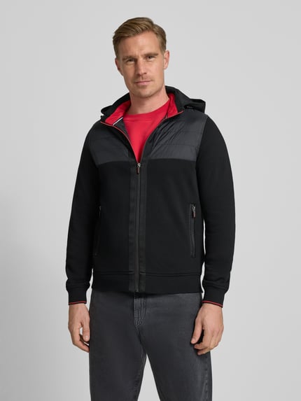 Mannelijk model draagt Regular Fit Jacke met gevoerde opstaande kraag van Christian Berg Men, puur katoen, met ritssluiting, capuchon, steekzakken met ritssluiting, elastische boorden, kleur zwart met rode accenten, vooraanzicht van het hele lichaam.