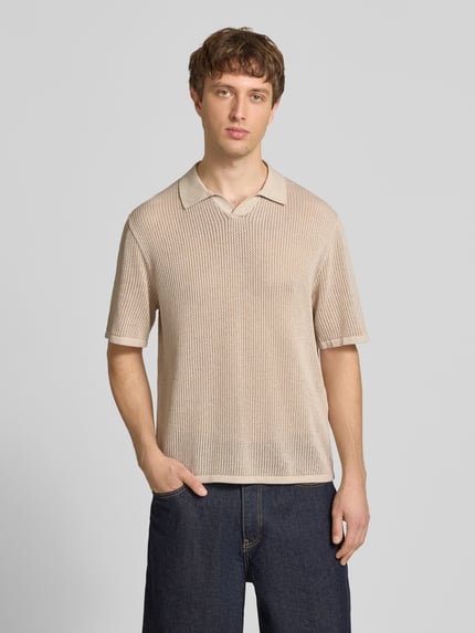 Männermodel trägt Regular Fit Strick-Poloshirt Modell 'CASSIS' von Jack & Jones aus reiner Baumwolle, V-Ausschnitt, beige, Ganzkörperansicht von vorne.