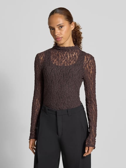 Modelka nosi Slim Fit Longsleeve aus Spitze od Rich & Royal z półprzezroczystego materiału, stójka, długość tyłu w rozmiarze S: 68 cm, widok na górną część ciała z przodu.