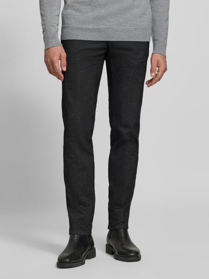 Männermodel trägt Schmale Hose aus Baumwoll-Mix Modell 'Fabio' von Brax in Dunkelgrau mit matter Textur, Herren Schmale Hose, Nahaufnahme Unterkörper.