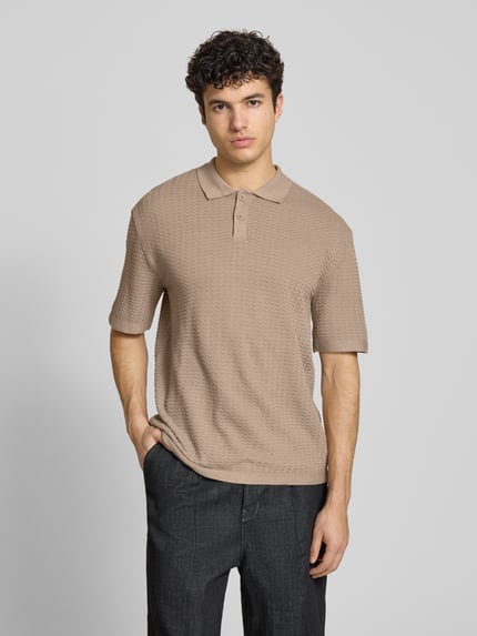 Männermodel trägt Relaxed Fit Poloshirt Modell 'FERDINAND' von Redefined Rebel aus reiner Baumwolle, Strickshirt in Beige, Knopfleiste, Ganzkörperansicht von vorne. Rückenlänge bei Größe M: 70 cm.