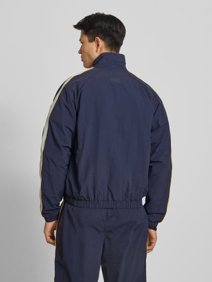 Männermodel trägt Trackjacket mit Label-Stitching Modell 'Slipstream' von PROHIBITED in Dunkelblau, Relaxed Fit, Rückansicht.