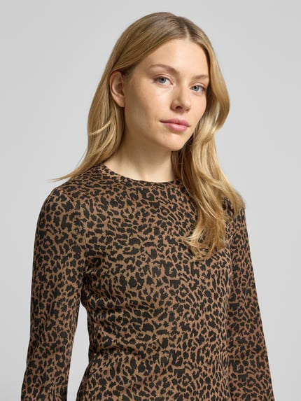 Vrouwenmodel draagt Regular Fit Freizeitkleid met Animal Print van Vero Moda, all-over animal print, lange mouwen, close-up bovenlichaam.