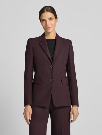 Kobiece modelka ma na sobie Slim Fit Blazer mit Viskose-Anteil od windsor., elastyczna mieszanka materiałów z dodatkiem wiskozy, krój slim fit, kołnierz z połami, listwa guzikowa, kieszenie z patką, długość tyłu w rozmiarze 36: 67 cm, szerokość w rozmiarze 36: 39 cm, długość rękawów w rozmiarze 36: 62 cm, widok całej sylwetki z przodu.